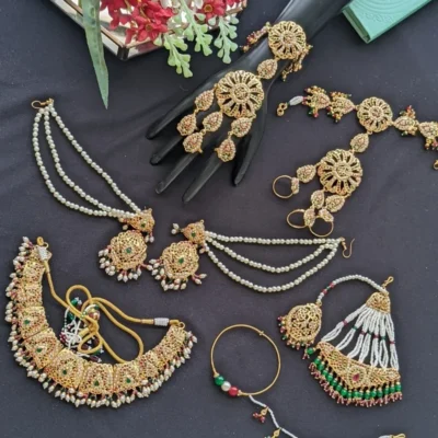 Dil-Nasheen Bridal Set close-up of ruby and emerald stones, Punjabi wedding bridal set with 22-carat gold-plated heavy jhumki.